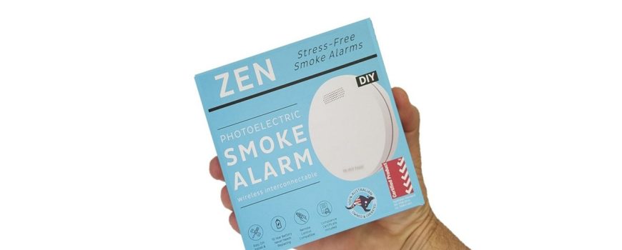 ZEN interconnected smoke alarm 1-pack box being held by hand - close up